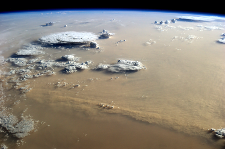 CAMELIA investiga el papel de los aerosoles minerales que se transportan en la atmósfera de la Tierra y Marte. (Arriba) Imagen de una tormenta de arena en la Tierra, sobre el desierto del Sahara en África, vista por el astronauta de la ESA Alexander Gerst desde la Estación Espacial Internacional. Crédito ESA. (Abajo) Imagen de una tormenta de polvo en Marte, visto por Mars Express, que capturó este frente ascendente de nubes de polvo, visible en la mitad derecha del cuadro, cerca del casquete polar norte de Marte (78 ° N / 106 ° E). Crédito: ESA/Mars Express.