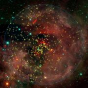 Cúmulo de estrellas jóvenes NGC 2244. El círculo central rojo indica la región aproximada en la que se han centrado la mayoría de estudios previos, y el círculo azul la región correspondiente al presente trabajo. Los símbolos amarillos indican a las estrellas jóvenes pertenecientes al cúmulo.